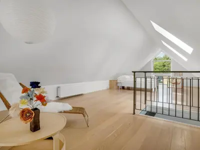 a white living room with a table and a couch at Holiday Home Anelle - 2-5km from the sea by Interhome in Blokhus