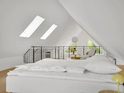 a white bedroom with a bed and a chair at Holiday Home Anelle - 2-5km from the sea by Interhome in Blokhus