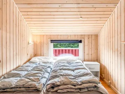 a large bed in a room with a window at Holiday Home Hans - 1-2km from the sea by Interhome in Løkken