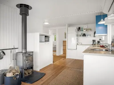 a kitchen with a stove in the middle of a room at Holiday Home Blia - 120m to the fjord by Interhome in Løgstør