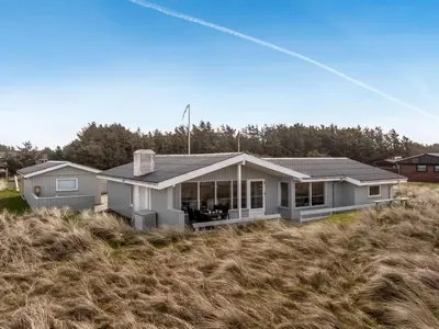 a house sitting on top of a field of grass at Holiday Home Fridgerd - 300m from the sea by Interhome in Løkken