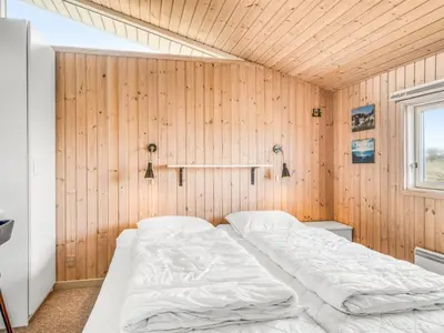 a bedroom with a bed in a wooden wall at Holiday Home Fridgerd - 300m from the sea by Interhome in Løkken