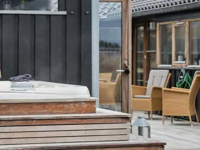 a sink on a patio with a table and chairs at Holiday Home Sinika - 100m from the sea by Interhome in Blokhus