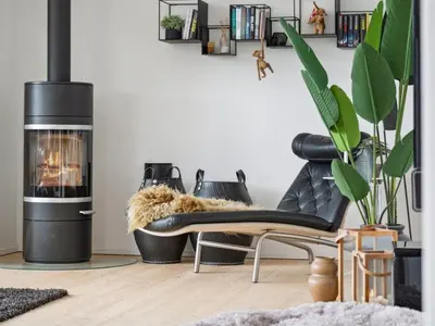 a living room with a couch and a fireplace at Holiday Home Sinika - 100m from the sea by Interhome in Blokhus