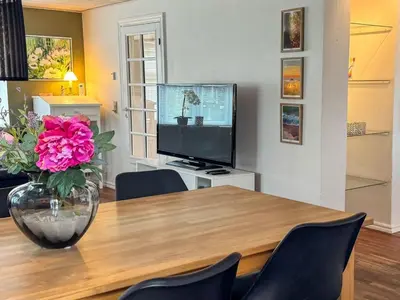 a dining room with a table with a vase of pink flowers at Holiday Home Elza - 2-5km from the sea by Interhome in Fjerritslev