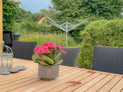 a vase with pink flowers sitting on a wooden table at Holiday Home Elza - 2-5km from the sea by Interhome in Fjerritslev