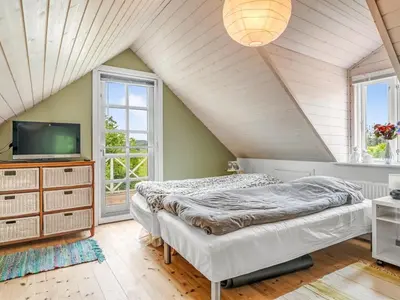 a attic bedroom with two beds and a tv at Holiday Home Elza - 2-5km from the sea by Interhome in Fjerritslev