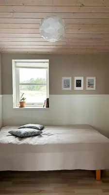 a bedroom with a large bed with a window at Beautiful Home Near Løkken On Secluded Plot in Løkken