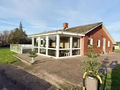 a house with a large screened in porch at Amtoft Vig Kitespot in Vesløs