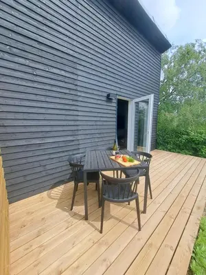 a patio with a table and chairs on a deck at Motel Glyngøre in Roslev
