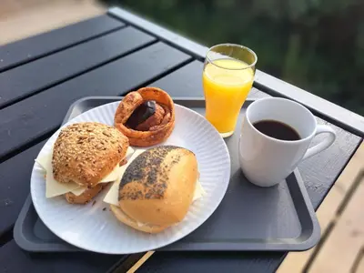 a tray with a plate of food and a cup of coffee at Motel Glyngøre in Roslev