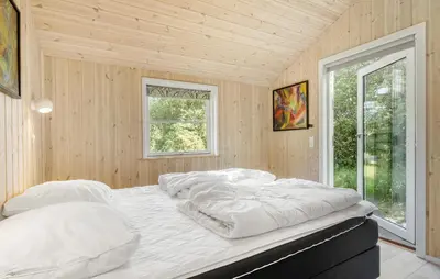 a large bed in a room with wooden walls at 4 Bedroom Stunning Home In Fjerritslev in Fjerritslev