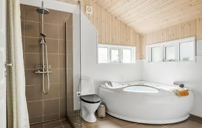 a bathroom with a large tub and a shower at 4 Bedroom Stunning Home In Fjerritslev in Fjerritslev