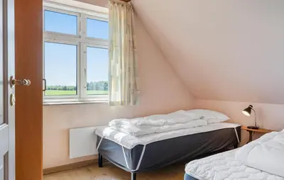 two beds in a room with a window at Stunning Home In Nykøbing M With Sauna in Alsted