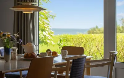 a dining room with a table and a view of a field at Stunning Home In Nykøbing M With Sauna in Alsted