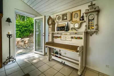 a home bar with a table and clocks on the wall at Country House With Fjord Views At Harre Vig in Roslev