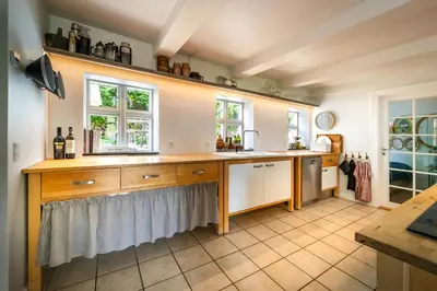 a kitchen with a counter and two windows at Country House With Fjord Views At Harre Vig in Roslev