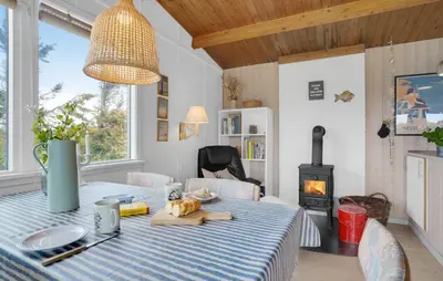 a dining room with a table and a wood stove at Pet Friendly Home In Thisted With Wifi in Thisted