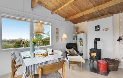 a living room with a table and a wood stove at Pet Friendly Home In Thisted With Wifi in Thisted