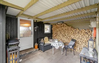 a patio with a table and a pile of wood at Pet Friendly Home In Thisted With Wifi in Thisted