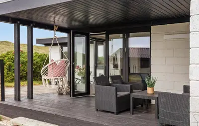 a screened porch with chairs and a swing at 3 Bedroom Nice Home In Harboøre in Harboør