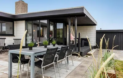 a patio with a table and chairs in front of a house at 3 Bedroom Nice Home In Harboøre in Harboør