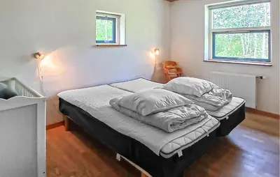 a bedroom with two beds and two windows at Beautiful Home In Højslev With Sauna in Højslev