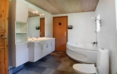 a bathroom with a tub and a toilet and a sink at Beautiful Home In Højslev With Sauna in Højslev