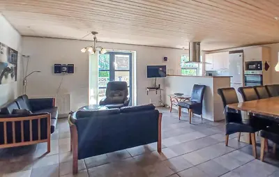 a living room with chairs and a table and a kitchen at Beautiful Home In Højslev With Sauna in Højslev