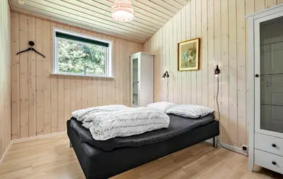 a bedroom with a bed in the corner of a room at Awesome Home In Løgstør With Wifi in Løgstør