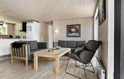 a living room with a couch and a table and chairs at Awesome Home In Løgstør With Wifi in Løgstør