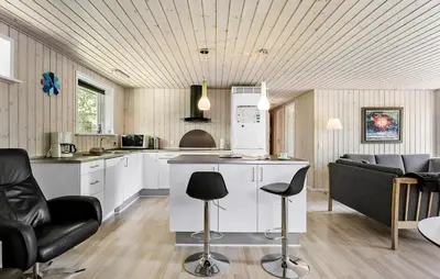 a kitchen with white cabinets and black bar stools at Awesome Home In Løgstør With Wifi in Løgstør