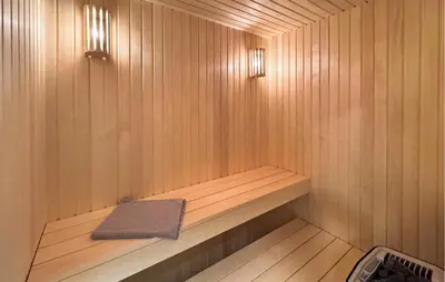 a wooden sauna with a towel on a shelf at Cozy Home In Vestervig With Sauna in Vestervig