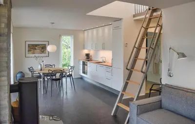 a kitchen and dining room with a spiral staircase in a house at Cozy Home In Vestervig With Sauna in Vestervig