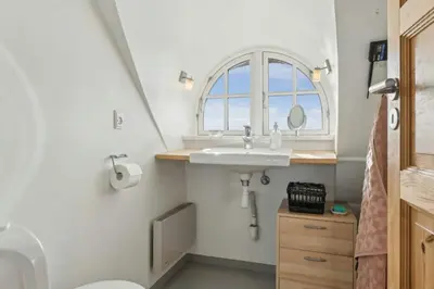 a bathroom with a sink and a window at Thatched Holiday Home By The North Sea In Blokhus in Blokhus