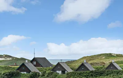 a row of houses on a hill with the ocean in the background at Gorgeous Home In Lemvig in Lemvig