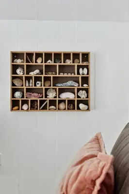 a person sitting on a couch looking at a display of rocks at Architect-Designed Wooden House At Ertebølle in Farsø