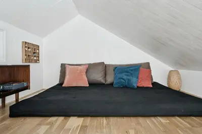 a bedroom with a couch with pillows on it at Architect-Designed Wooden House At Ertebølle in Farsø