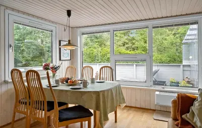 a dining room with a table and chairs and windows at Stunning Home In Hurup Thy With Wifi in Sønder Ydby