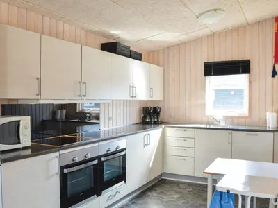 a kitchen with white cabinets and a table in it at 4 star holiday home in Thyborøn in Thyborøn