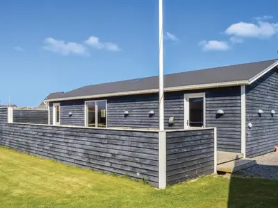 a blue building with a fence in front of it at 4 star holiday home in Thyborøn in Thyborøn