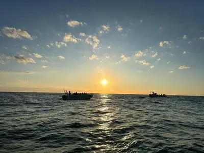 two boats in the ocean at sunset at 4 star holiday home in Thyborøn in Thyborøn