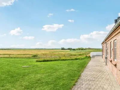 a brick building with a field in the background at 4 star holiday home in Harboøre in Harboør