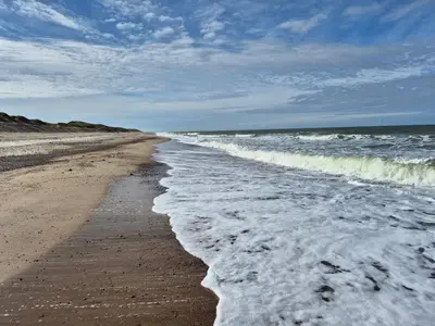 an empty beach with waves crashing on the shore at 4 star holiday home in Harboøre in Harboør
