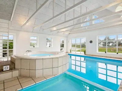 a large pool with a tub in a room with windows at 4 star holiday home in Harboøre in Harboør