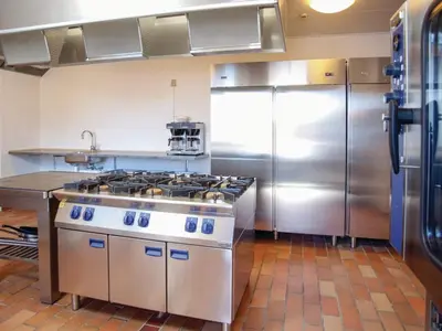 a kitchen with a stove and a stainless steel refrigerator at 5 star holiday home in Thyborøn in Thyborøn