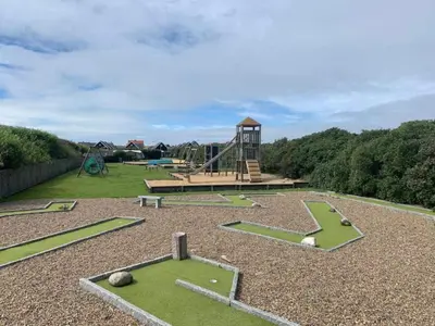 a park with a playground with a slide at 4 star holiday home in Thyborøn in Thyborøn