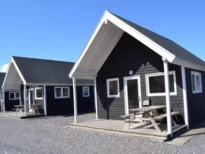 a black and white house with a picnic table outside at 4 star holiday home in Thyborøn in Thyborøn