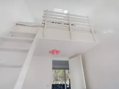 a white room with two bunk beds and a window at 4 star holiday home in Blokhus in Blokhus