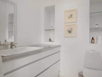 a white bathroom with a sink and a mirror at 4 star holiday home in Blokhus in Blokhus